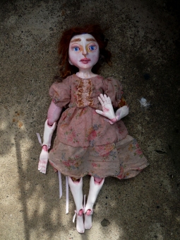 dreamy image of a sculpted art doll in vintage clothing