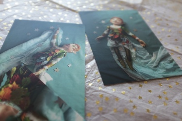 three peter pan postcards scattered over a desk covered in vintage pastels and sparkling stars