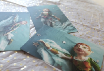 desk in soft blues and gold stars showing three postcards with images of peter pan