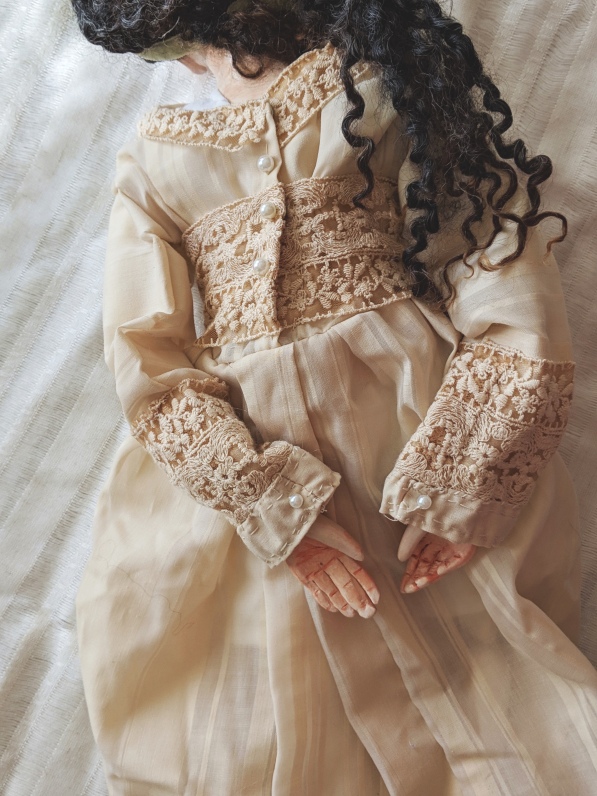 antique linen doll dress with delicate hand stitching, lace, and pearl buttons