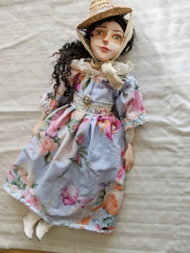 historic art doll in blue floral regency dress and straw hat